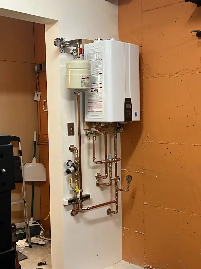 Plumbing technician inspecting water heater connections in Tuckerton